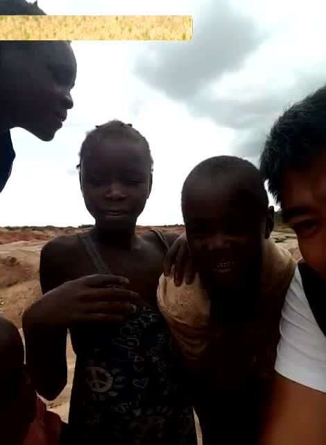 非洲小孩好奇盯着手机自拍,似乎是原始人