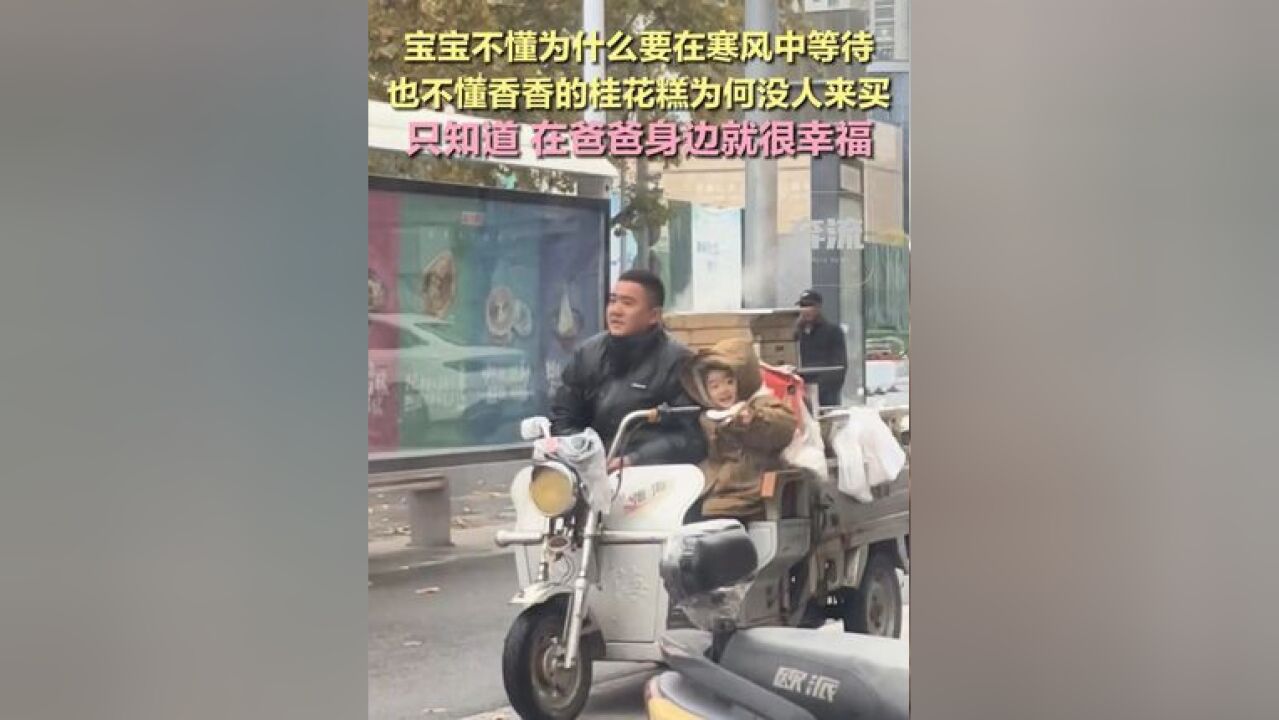 宝宝不懂为什么要在寒风中等待,也不懂香香的桂花糕为何没人来买,只知道,在爸爸身边就很幸福