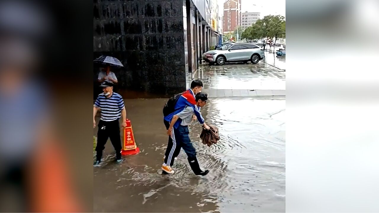 3门卫大爷挨个背学生穿过积水区 拍摄者:最年轻的也有50岁