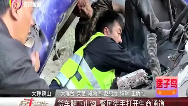 货车翻下山沟 警民徒手打开生命通道