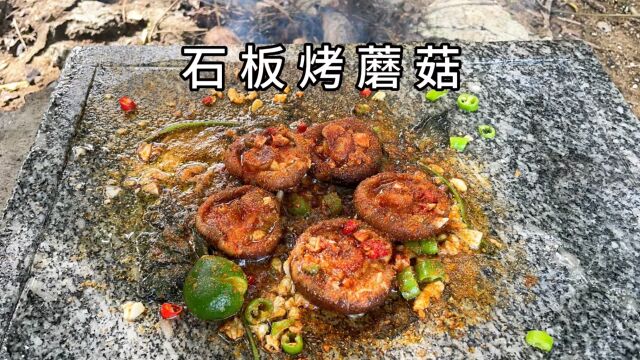 小伙在树上采摘到蘑菇,拿到石板上烧烤,味道棒极了