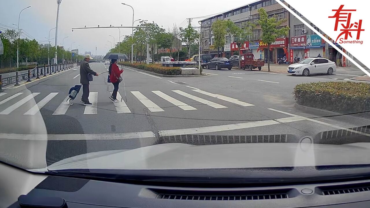 温暖人心!男子行车路上遇盲人过马路帮挡车流 后方车辆也都耐心等待