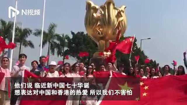 香港大学生在金紫荆广场与国旗和紫荆花合影,告白祖国