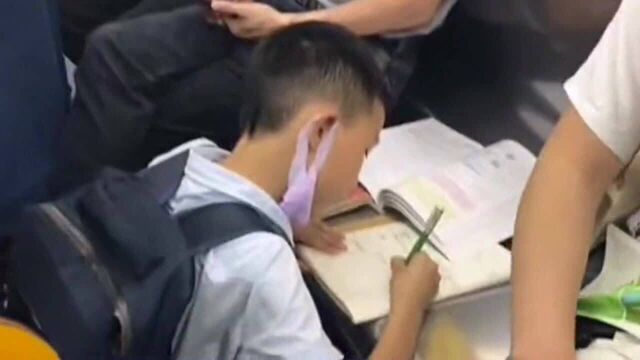 小男孩儿地铁上飞速占座,只为能趴在座位上写作业,学生的苦你体会不到!