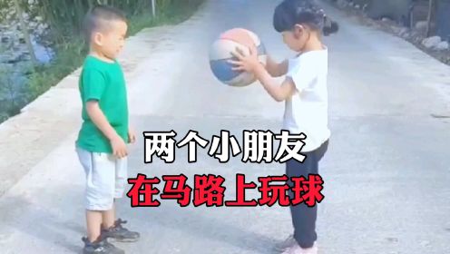 两个小朋友，在马路上玩球