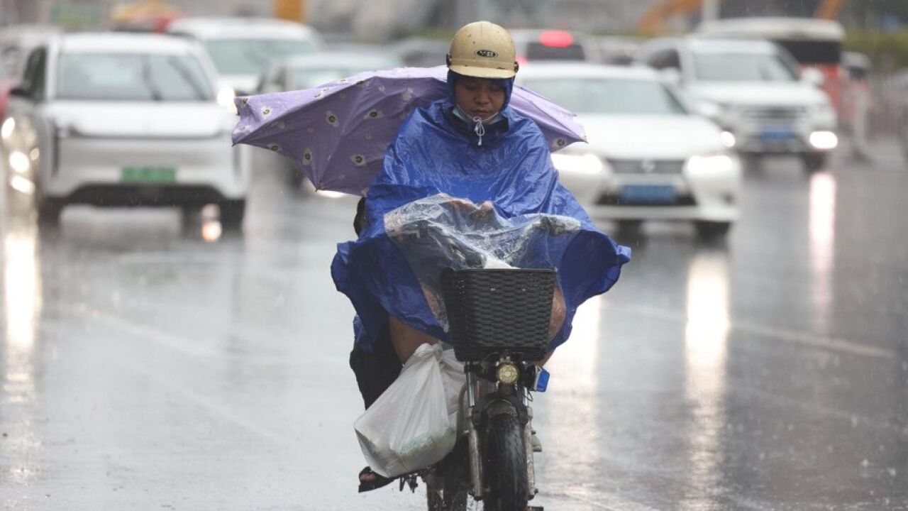 受强雷雨影响,广州多区发布雷雨大风黄色预警,市民撑伞慢行