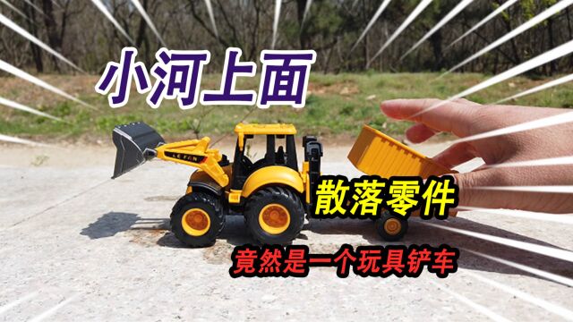 野外小河上散落了一堆零件,全部捡起来组装,竟然是一个玩具铲车