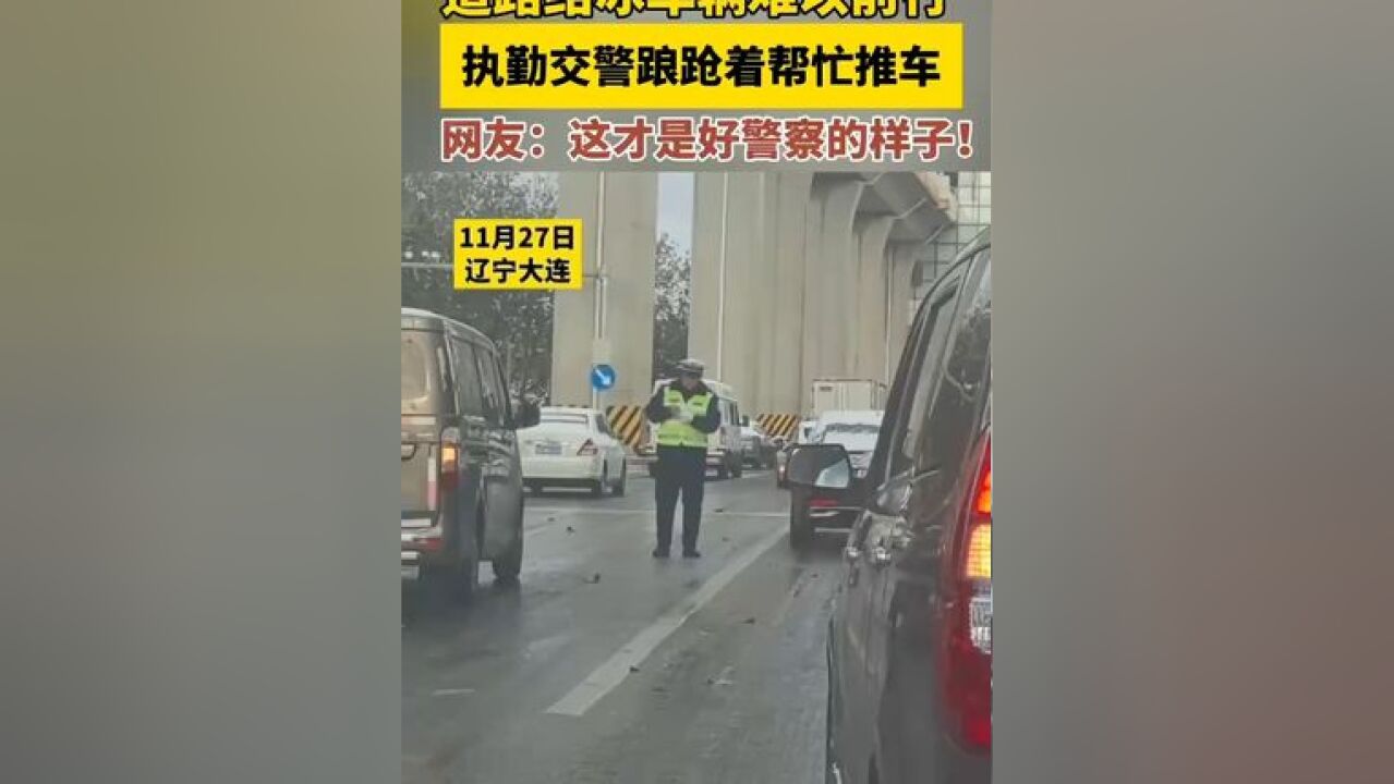 11月27日 辽宁大连,道路结冰车辆难以前行,执勤交警踉跄着帮忙推车,网友:这才是好警察的样子!来源:金彩云