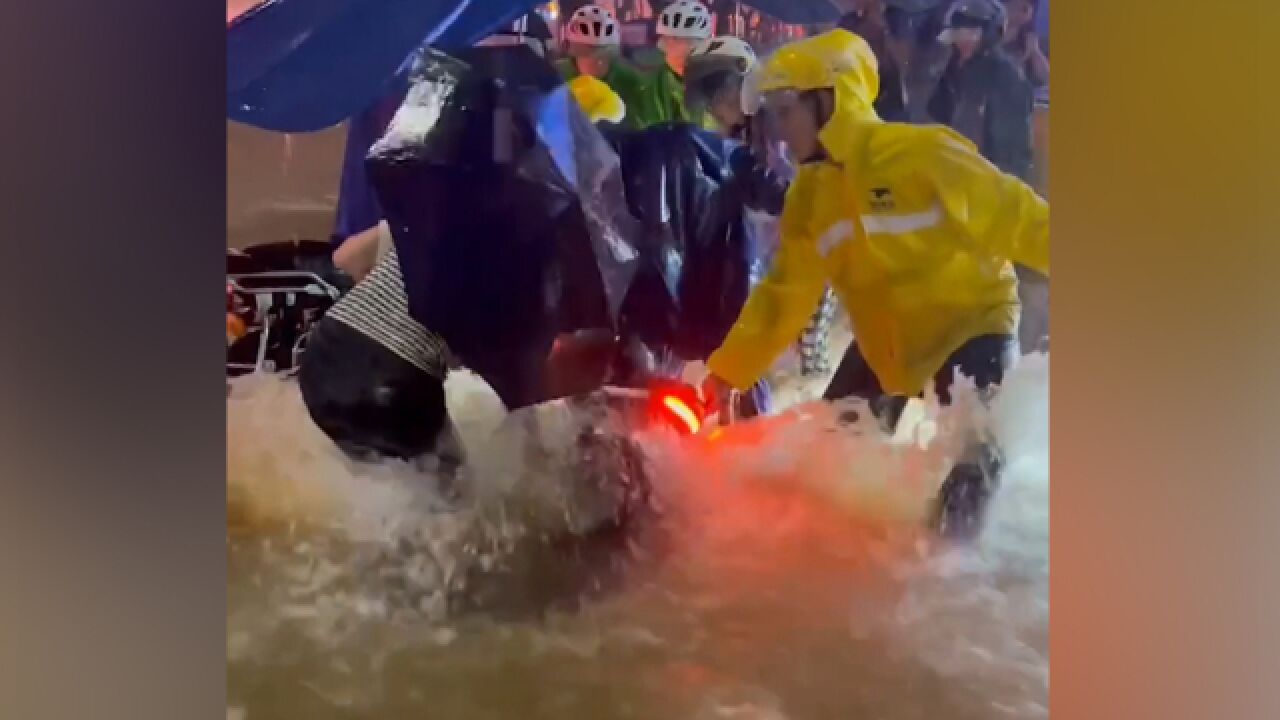 现场!深圳暴雨:水流湍急 外卖小哥急流中帮市民拽起电动车