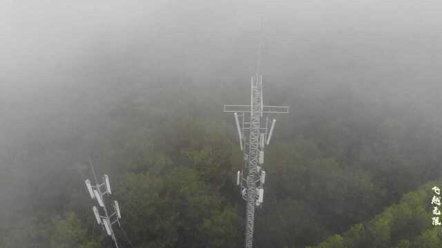 无人机穿越雨雾航拍建在农村山区里的中国移动信号塔