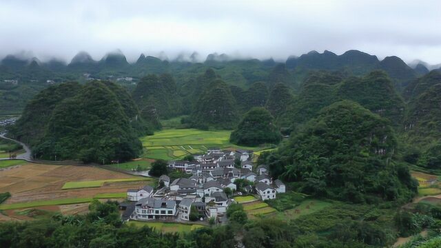 贵州大山里一处世外桃源,群山环绕下有一村子,云雾缭绕美极了