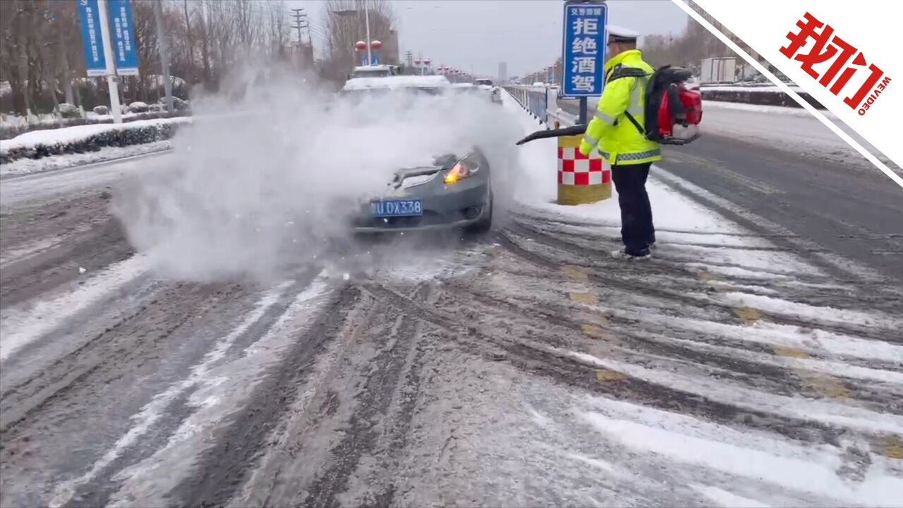 现场:青岛市迎来强降雪天气 交警身背除雪机为过往车辆清理积雪