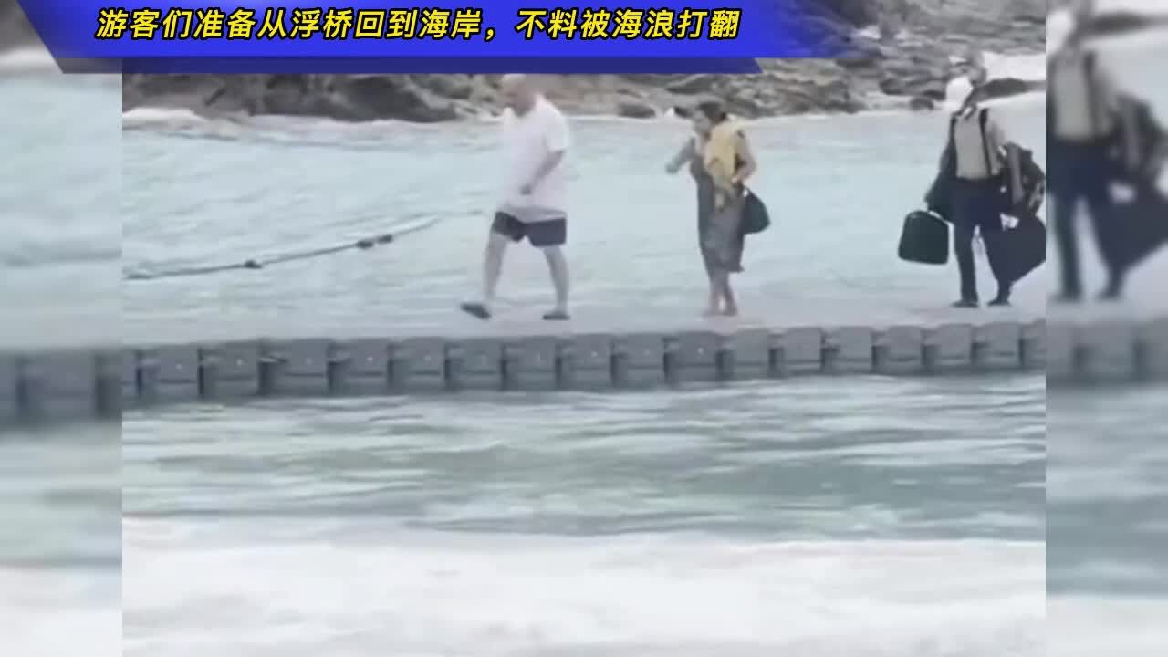 游客们准备从浮桥回到海岸,不料被海浪打翻