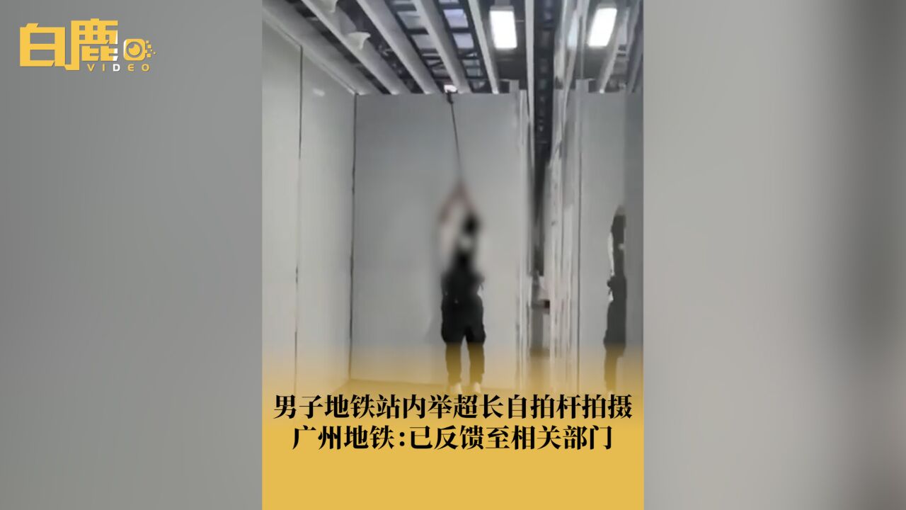 男子地铁站内举超长自拍杆拍摄