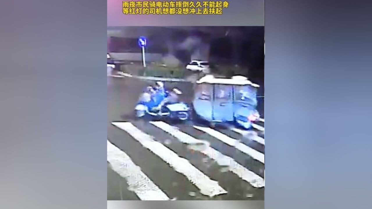 雨夜市民骑电动车摔倒久久不能起身 等红灯的司机想都没想冲上去扶起来