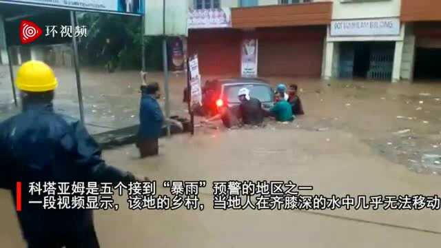 印度喀拉拉邦遭遇暴雨袭击:民众在齐腰深的积水中艰难推车