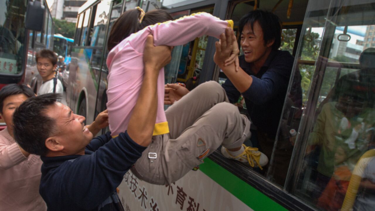 两男子将一女子塞进公交车