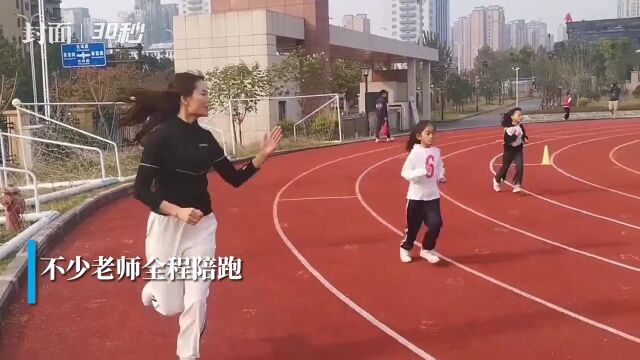 30秒|小学运动会老师全程陪跑 鼓励学生加油向前冲