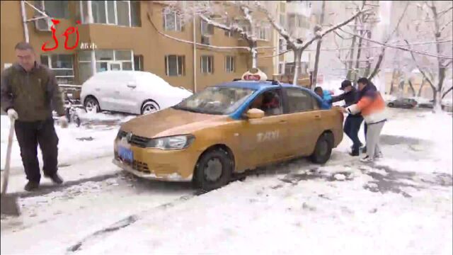 雨夹雪光临哈尔滨 路面结冰多车打滑 司机路人一起帮助推车