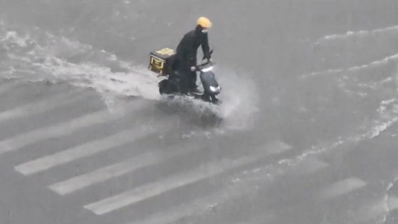 洛阳暴雨积水成河,外卖小哥冒雨送餐,骑着电动车“乘风破浪”