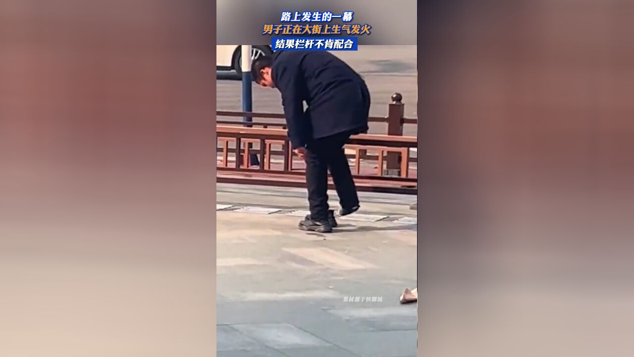 男子正在大街上生气发火,结果栏杆不肯配合