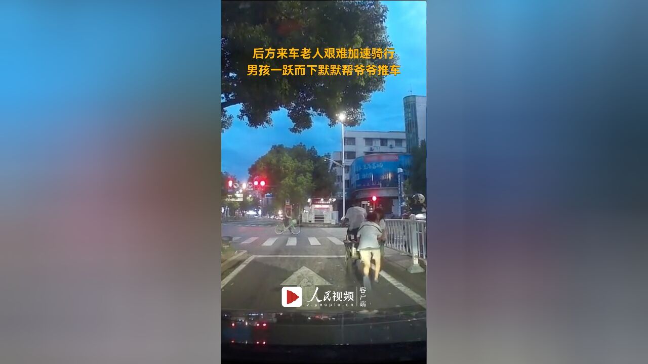 后方来车老人艰难加速骑行,男孩一跃而下默默帮爷爷推车