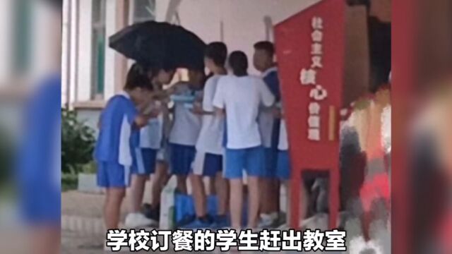 学生未在校内订餐被赶出校门,只能在校外淋雨吃饭