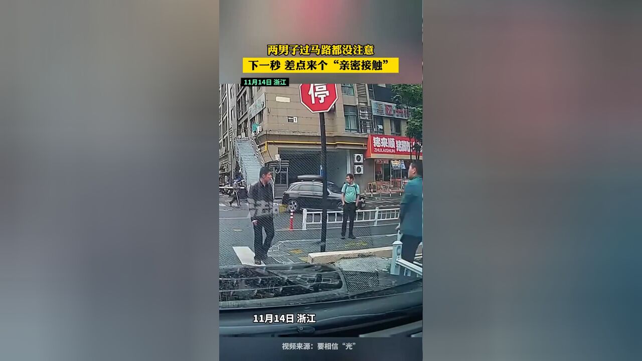 两男子过马路都没注意 下一秒 差点来个“亲密接触”