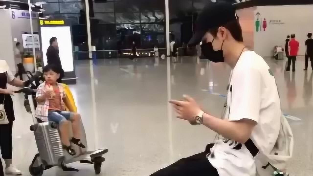 机场偶遇王一博坐行李箱上玩手机脚竟然碰不到地