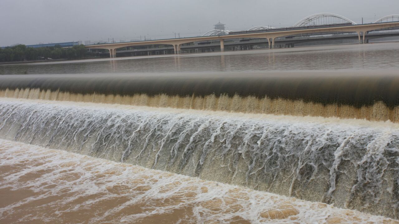 西安连降雨灞河河水上涨,滚滚洪水形成几百米长壮观瀑布,挺震撼