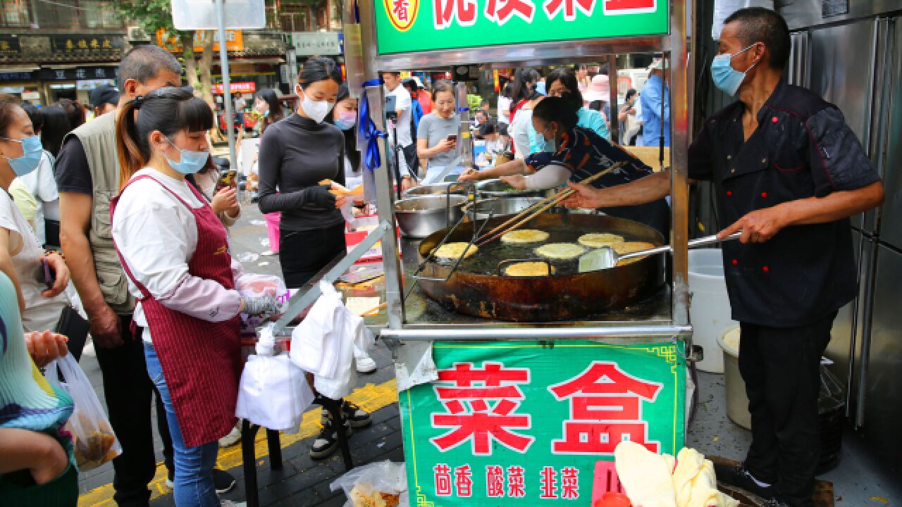 西安城墙根早市美食多,众多市民赶早市排长队吃早餐