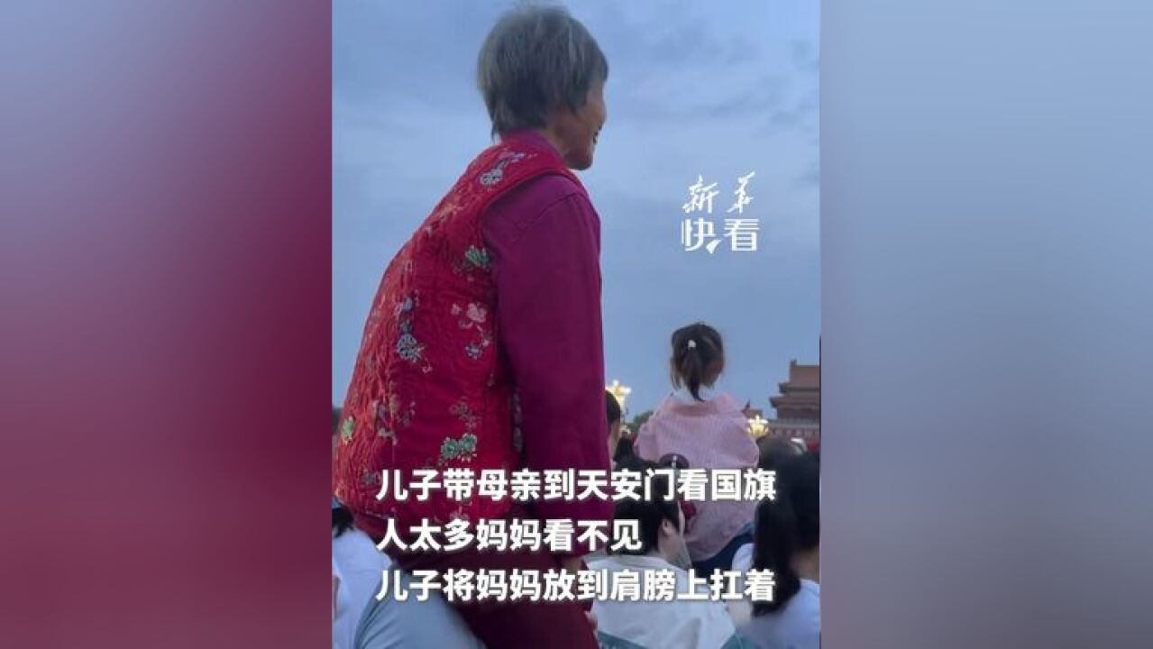 儿子带母亲到天安门看国旗,人太多妈妈看不见,儿子直接将妈妈放到肩膀上扛着(新华社快看)