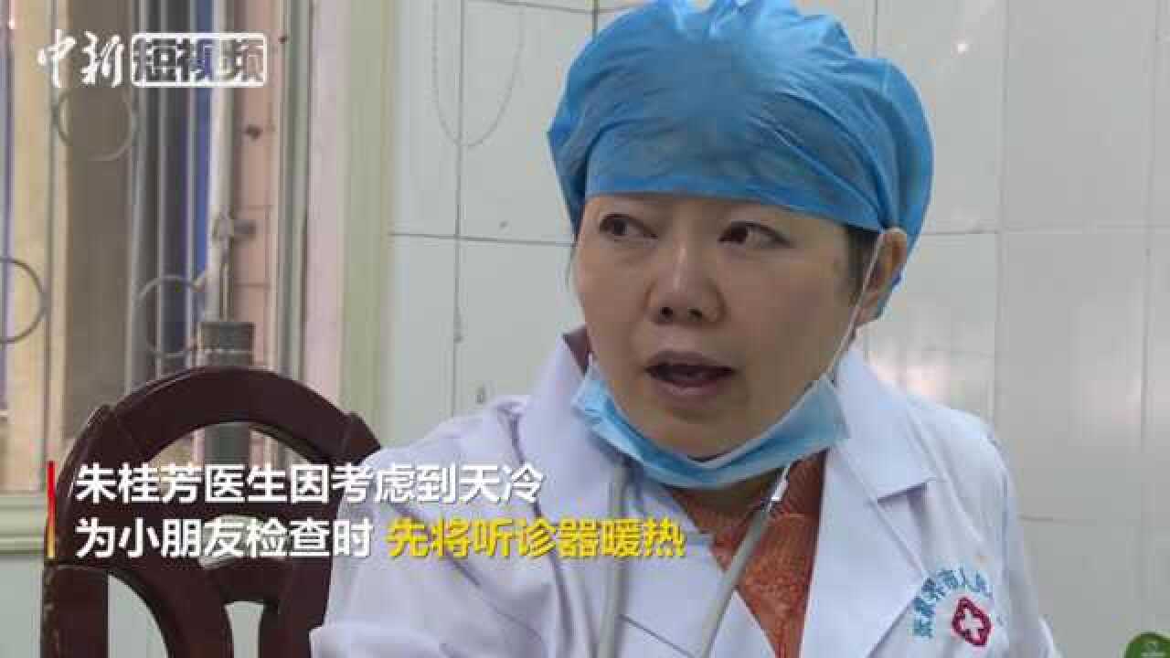 暖心!儿科医生用热水袋捂热听诊器后为患儿看病