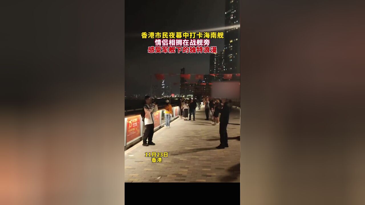 香港市民夜幕中打卡海南舰,不少情侣相拥在战舰旁,感受军舰下的独特浪漫