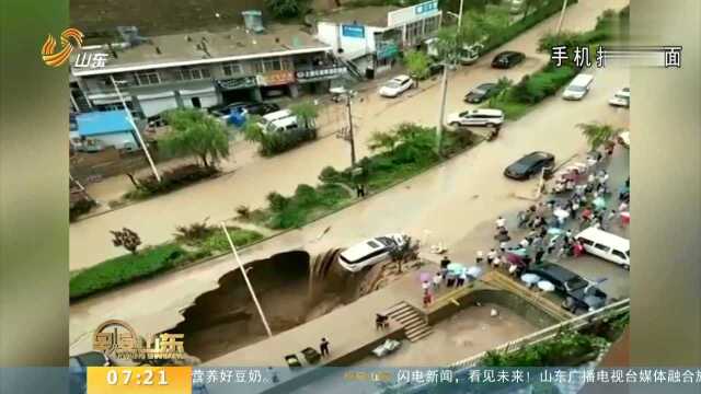 陕西延安:暴雨突降路面塌方 众人救援悬挂车辆