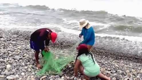海边迎着风浪撒网捉鱼，收获还不错