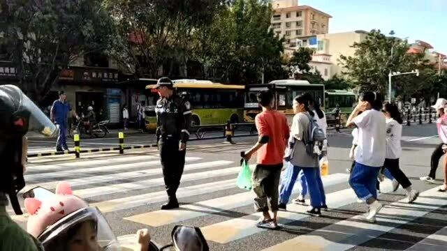 街头拍下暖心的一幕,交警同志护送孩子们过马路,一位学生向他敬礼!