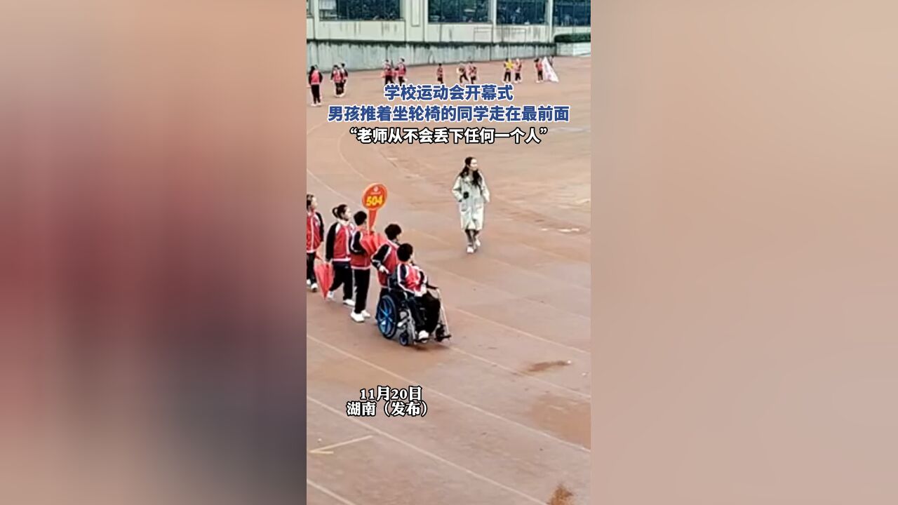 学校运动会开幕式,男孩推着坐轮椅的同学走在最前面