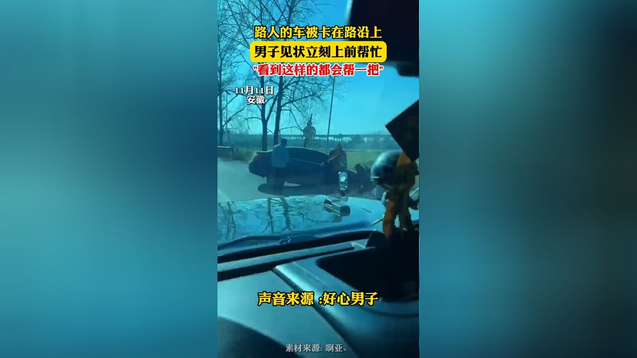 路人的车被卡在路沿上,男子见状立刻上前帮忙