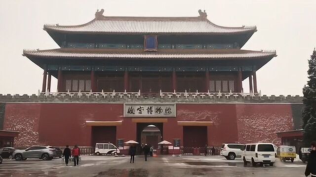 故宫红墙黄瓦映白雪 围墙外游客络绎不绝忙拍照