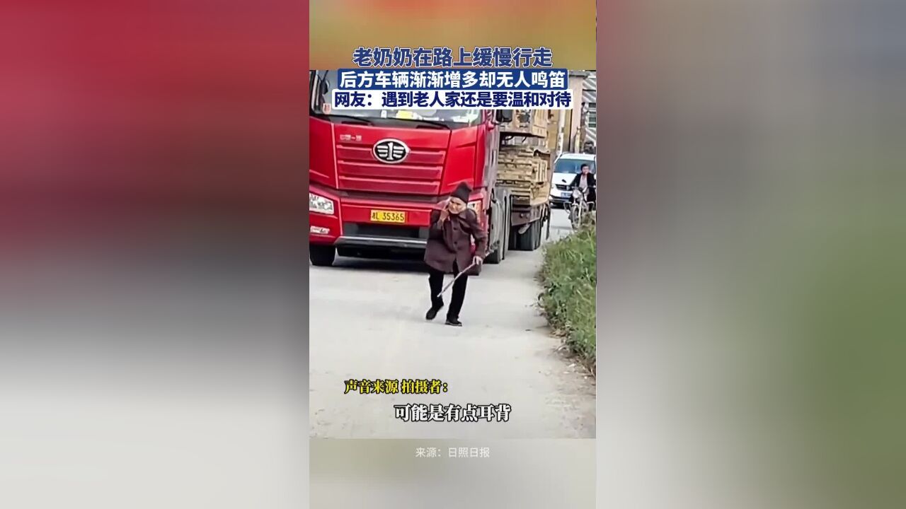 老奶奶在路上缓慢行走,后方车辆渐渐增多却无人鸣笛