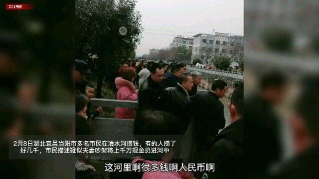 当阳市多名市民在河中用网捞钱,有的人捞了上千元