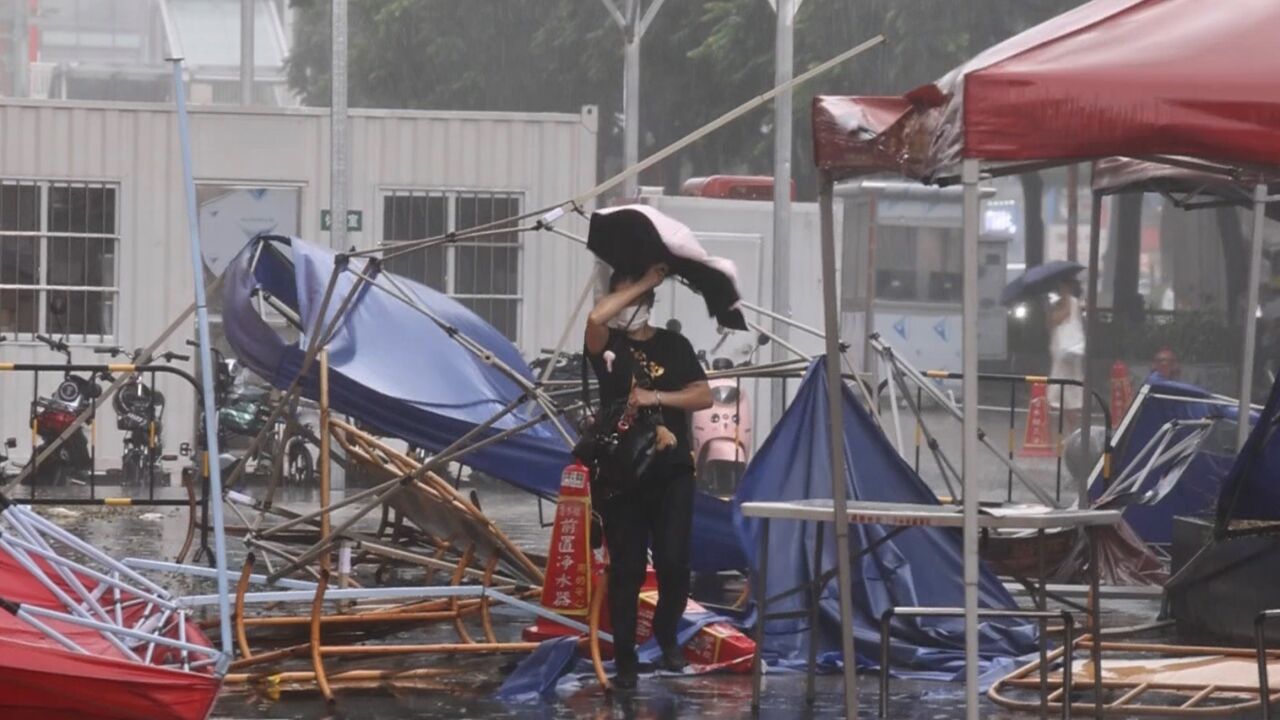 暴雨大风下广州市民撑伞慢行,多区发布雷雨大风黄色预警