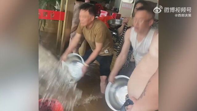 抚州暴雨居民拿盆舀店内过膝积水