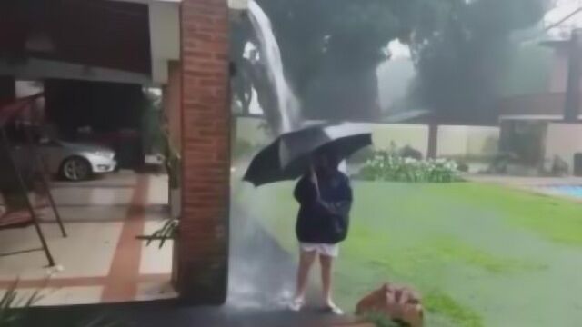 女子雷雨天打伞淋雨一道闪电从天而降