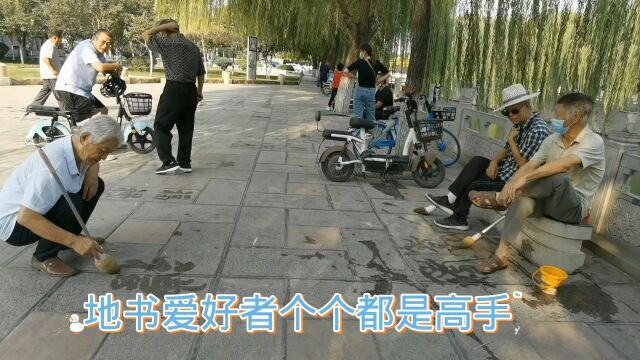 邯郸学步桥广场练地书的老年人个个都是高手,楷行篆隶草样样有.