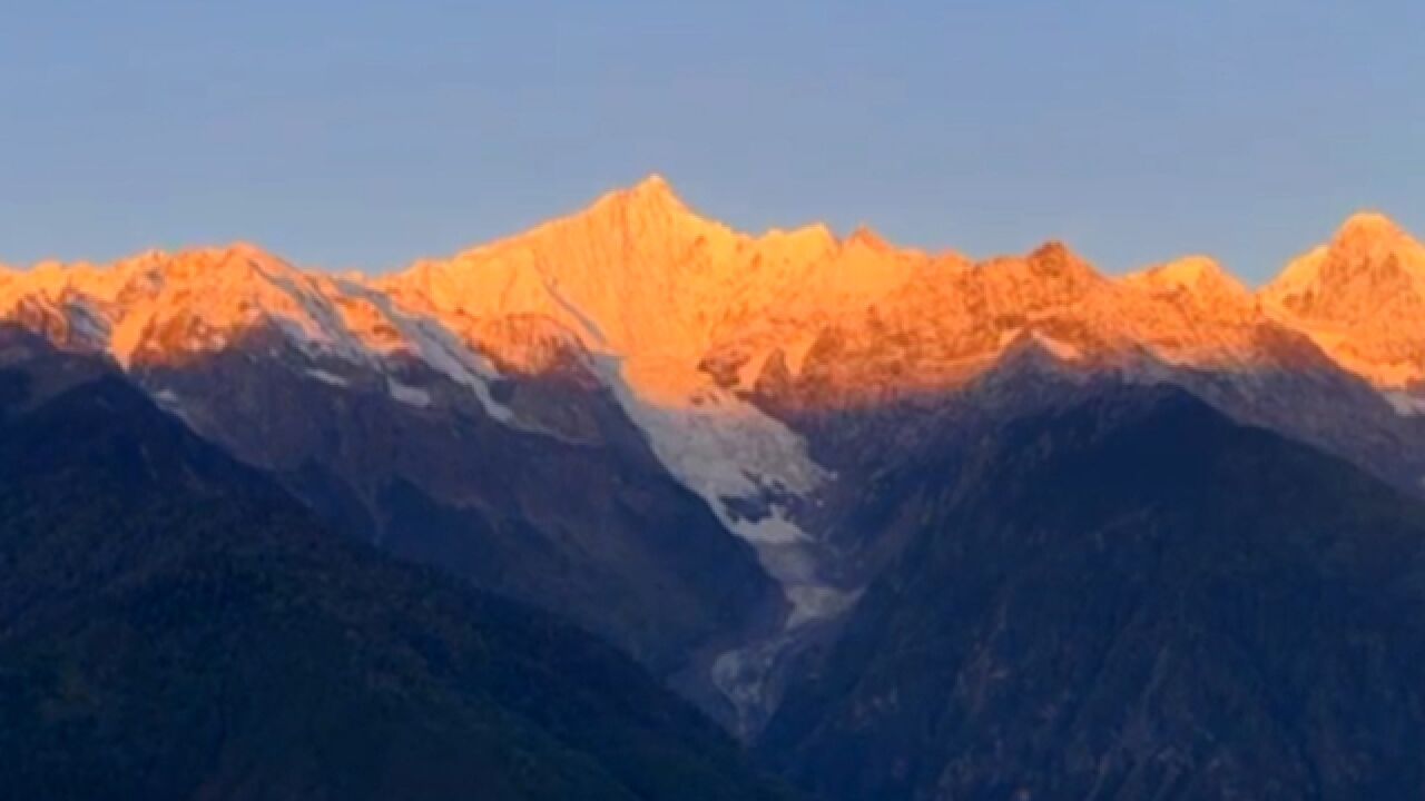 梅里雪山现日照金山!“金山”漂浮云层之上 极为壮观震撼