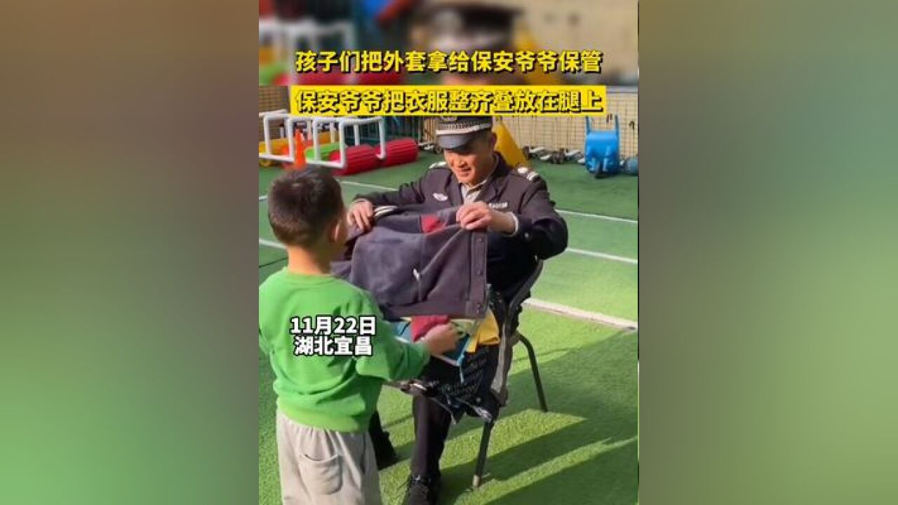 孩子们把外套拿给保安爷爷保管,保安爷爷把衣服整齐叠放在腿上