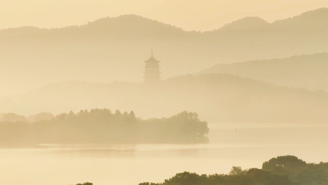 晚秋晨雾里的杭州西湖:水上扁舟若隐若现树影婆娑如画中秘境