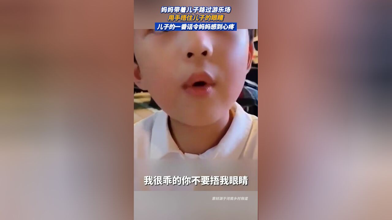 妈妈带着儿子路过游乐场,用手捂住儿子的眼睛